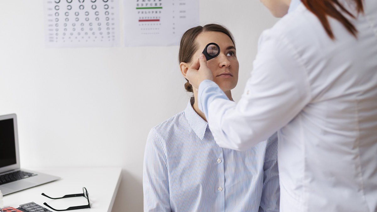 Une femme se fait examiner l'œil par un médecin avec une loupe, test de la vue en arrière-plan